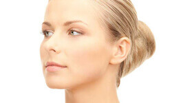 Side view of a woman showing the results of her facelift with necklift procedure.