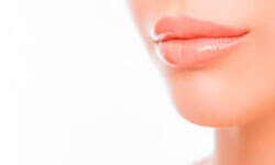 Close up view of a woman’s lips showing the results of a fat transfer to the lips procedure.