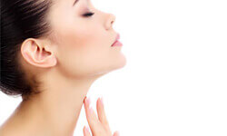 A side view picture of a woman pleased with her neck and chin liposuction procedure.