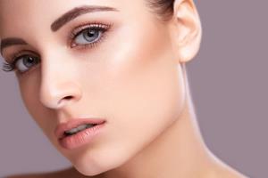 Close-up portrait picture of a beautiful woman’s face, showing the ear surgery procedure she had in Costa Rica.