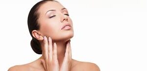 Profile close-up picture of a woman’s face, with both hands held up to her chin, showing the neck liposuction procedure she had in Costa Rica.