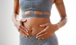 Picture of a woman in a two piece matching halter and shorts outfit showing her abdomen and hips liposuction procedure she had in Costa Rica.