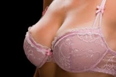 Photo of a woman in a light pink bra showing the results of her breast lift procedure she had in Costa Rica.