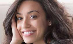 Picture of a smiling brunette, showing dental procedures available in Costa Rica.