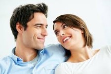 Portrait shot of a smiling man, hugging a woman, and illustrating his hair replacement procedure he had in Costa Rica.