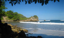 Picture of a beautiful Costa Rica beach with waves breaking on a sandy shore.