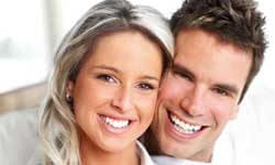 Picture of a smiling couple, standing, proud of their dental treatment in Costa Rica