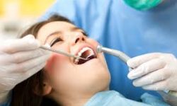 Picture of a smiling woman in a dental chair showing her happiness with the holistic oral surgery treatment she is receiving.