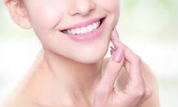 Picture of a smiling woman holding a hand to her jaw showing her happiness with the holistic oxygen dental treatment she had.