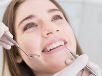 Picture of a smiling female in a dental chair showing her happiness with the holistic pediatric dental treatment she is receiving.