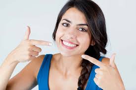 Picture of a smiling woman showing her happiness with the holistic periodontal treatment she is receiving.