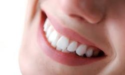 Picture of a smiling woman holding with invisible braces on her teeth, showing her happiness with the Invisalign invisible braces aligners procedure she had in Costa Rica.