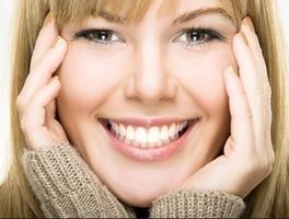 Picture of a smiling woman holding her hands to the side of her face, showing her happiness with the sinus lift procedure she had in Costa Rica.