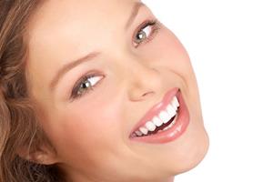Picture of a smiling woman displaying her top teeth with the zirconium veneers she had in Costa Rica.