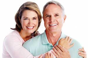 Portrait picture of a smiling couple, together facing the camera, happy with their dental procedure in Costa Rica