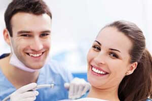 Portrait picture of a smiling Costa Rican dentist and his patient.